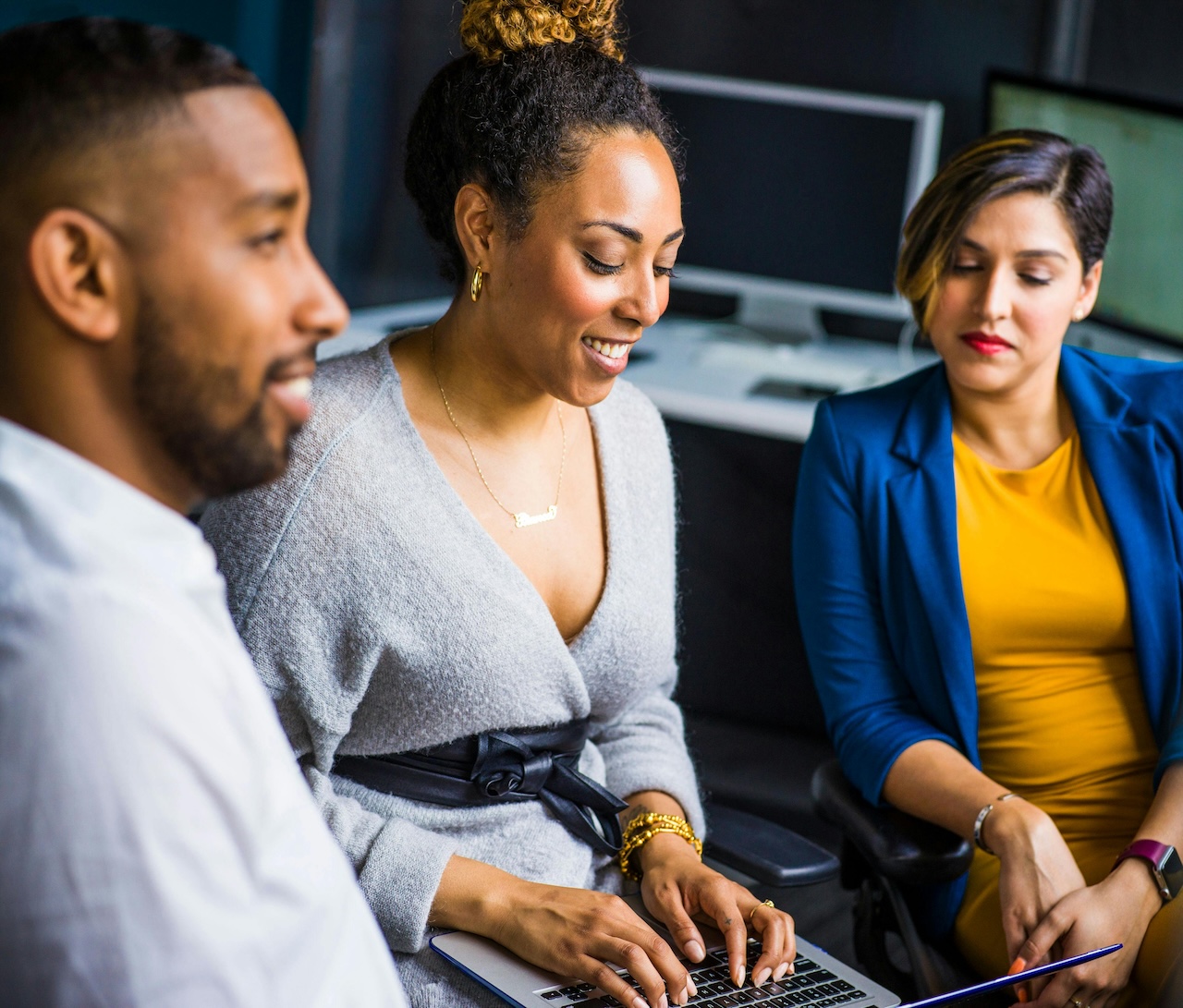 Three people looking at a laptop screen